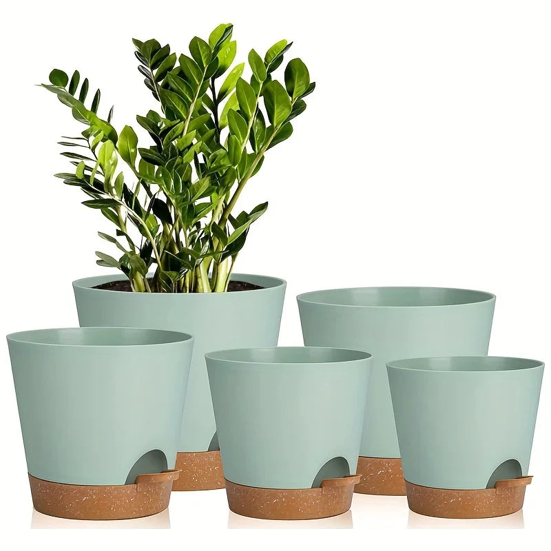 A set of five light green self-watering plant pots with drainage holes, shown in various sizes.