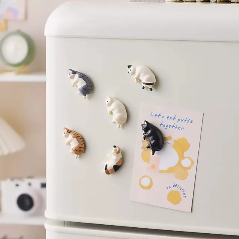 A white fridge featuring six cat designs, including a striped cat and several white cats, with a sign that reads Lets eat puf