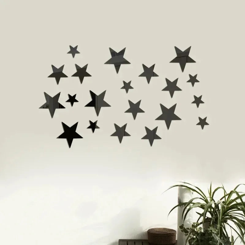 A black star wall decor set made of 3D acrylic mounted on a light-colored wall.