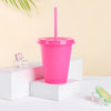 A bright pink plastic cold cup with a lid and straw is displayed on a white surface.