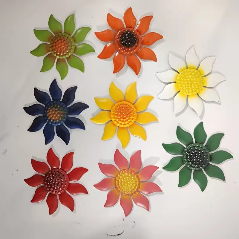 A set of nine metal flower wall decorations in various shades of orange, yellow, green, and blue.