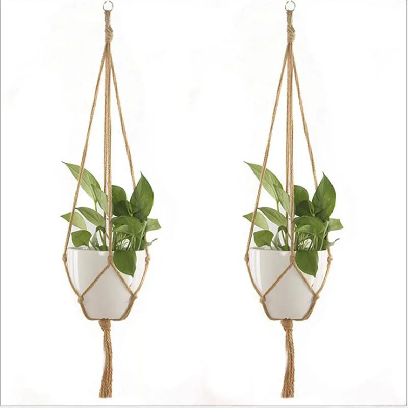 Handmade macrame plant hanger with a woven rope and white pot holding green foliage.