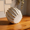 Elegant white and gold resin decorative pumpkins displayed on a wooden surface.