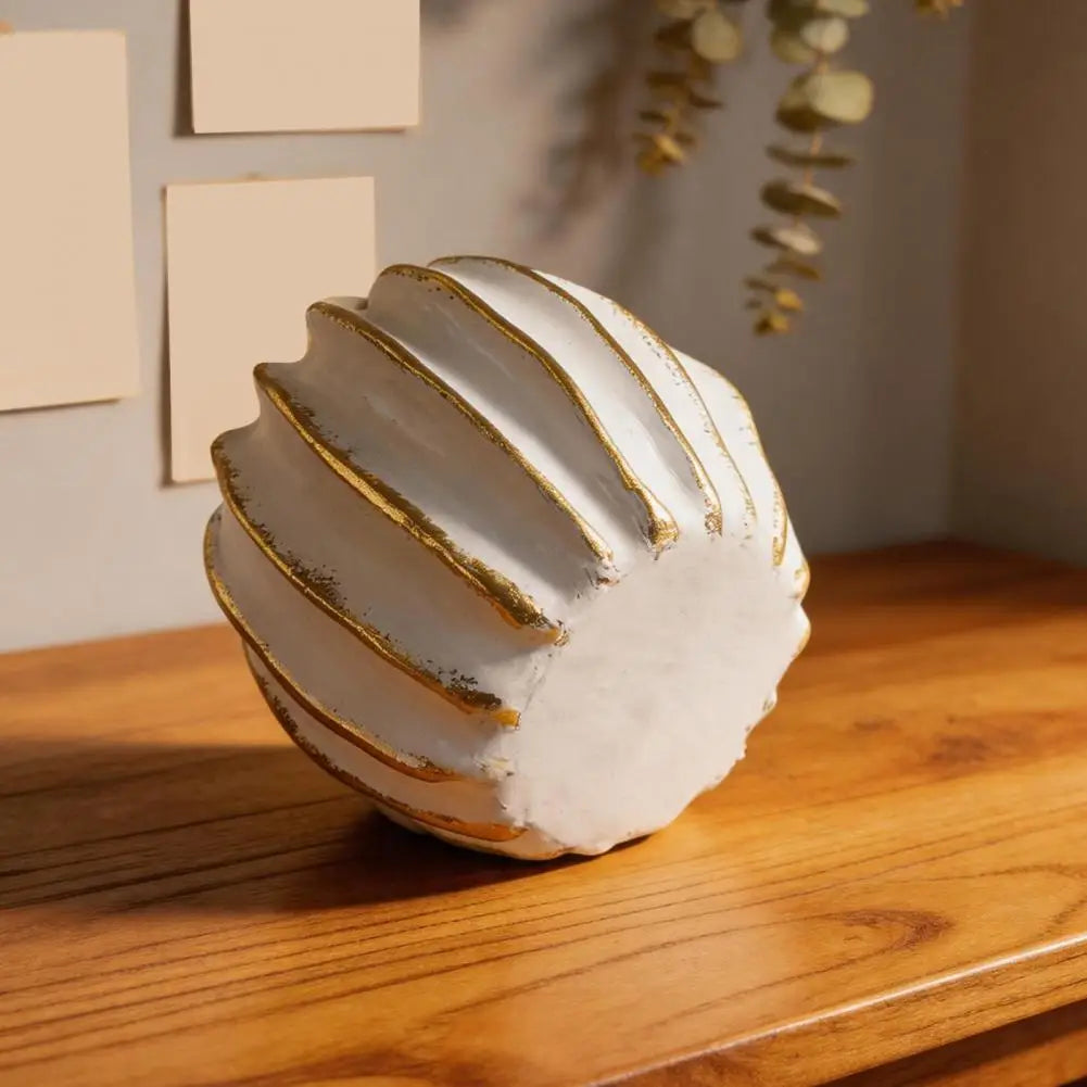 Elegant white and gold resin decorative pumpkins displayed on a wooden surface.