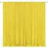 A vertical yellow pleated fabric drape used as an elegant backdrop for events.