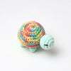 Handmade crocheted turtle plush with a colorful, textured shell and light blue body.