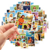 A hand holds a collection of colorful Christian faith stickers featuring inspirational images of Jesus and biblical scenes.