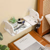 A white adhesive elephant storage rack mounted on a wall, holding various items like glasses and a smartphone.