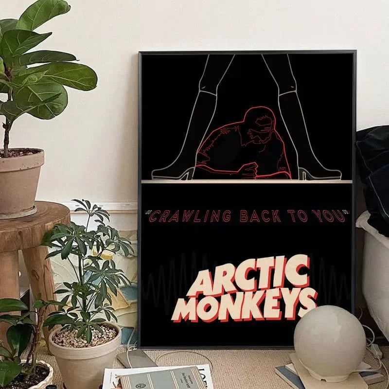 A black canvas art print featuring a silhouette of hands and the text CRAWLING BACK TO YOU and ARCTIC MONKEYS in orange font.