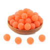 A pile of bright orange textured resin beads for jewelry making