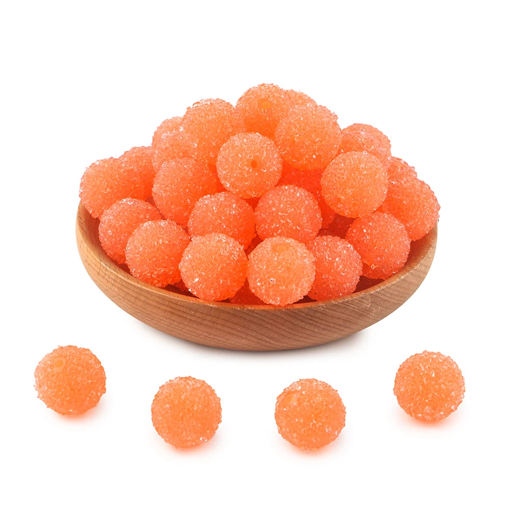 A pile of bright orange textured resin beads for jewelry making
