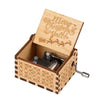 A vintage hand-cranked wooden music box with a lid engraved with Merry Christmas Yall