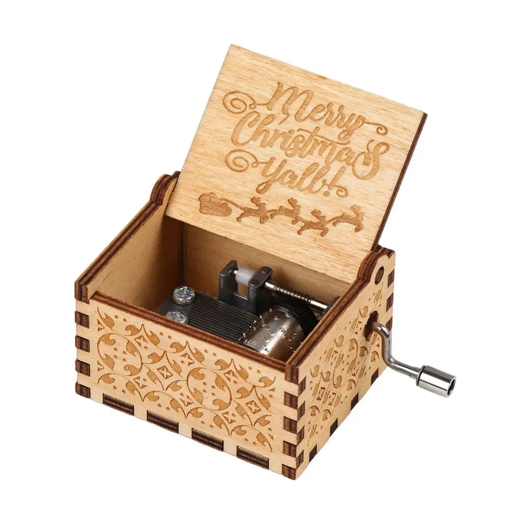 A vintage hand-cranked wooden music box with a lid engraved with Merry Christmas Yall