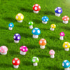 A collection of colorful resin mini mushroom figurines scattered across vibrant green grass.