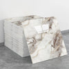 A stack of self-adhesive marble tile stickers featuring a beige and brown veined marble pattern.