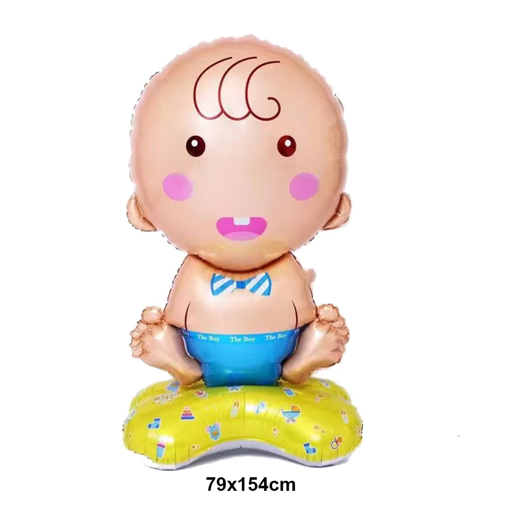 A round, light pink foil balloon shaped like a baby with a bow tie sitting on a yellow base.