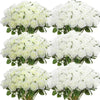 A collection of white artificial silk roses arranged in bouquets for table decor.