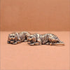 A pair of vintage brass tiger figurines in a striped pattern lying side by side on a neutral background.