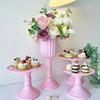 Pink elegant cylinder flower vases with white and pink roses and greenery on a white surface