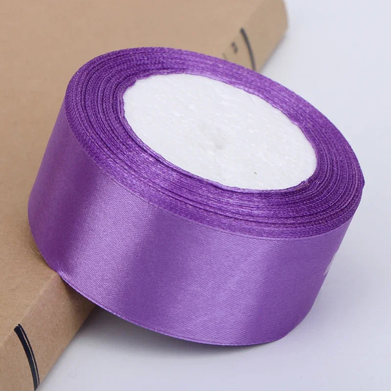Roll of purple satin ribbon with white filling for crafts and gift wrapping