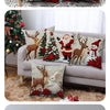A set of four festive Christmas linen throw pillow covers featuring deer and reindeer designs on a gray sofa.