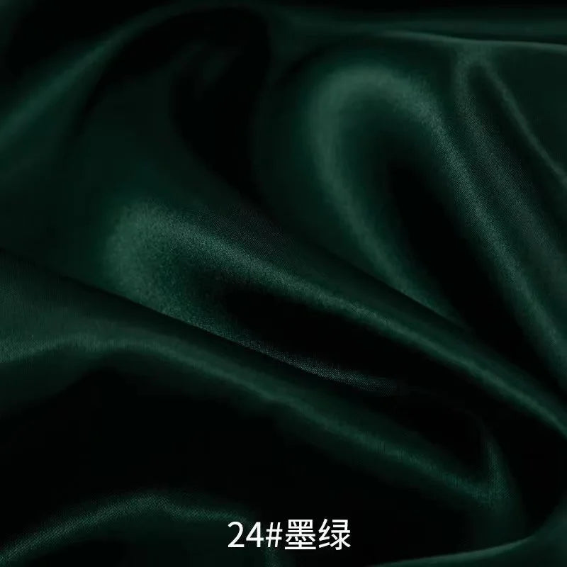 Dark emerald green satin fabric draped and folded