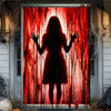 A silhouette of a woman covered in dripping red blood is displayed on a window banner for Halloween decor.