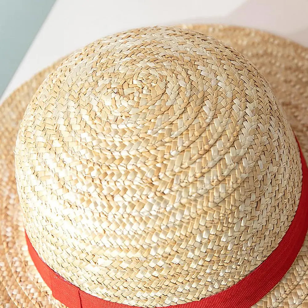 A close-up of a straw hat with a red band, showing the woven texture for cosplay and sun protection.