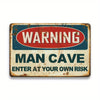 A vintage metal tin sign with a distressed blue and red warning sign for a man cave that reads WARNING MAN CAVE ENTER AT YOUR