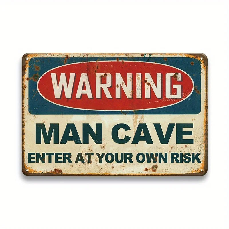 A vintage metal tin sign with a distressed blue and red warning sign for a man cave that reads WARNING MAN CAVE ENTER AT YOUR