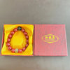 A collection of natural cinnabar stone zodiac bracelets displayed in yellow and pink boxes.