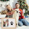A family of three posing with a golden retriever, next to a wooden photo frame kit for pet paw prints.