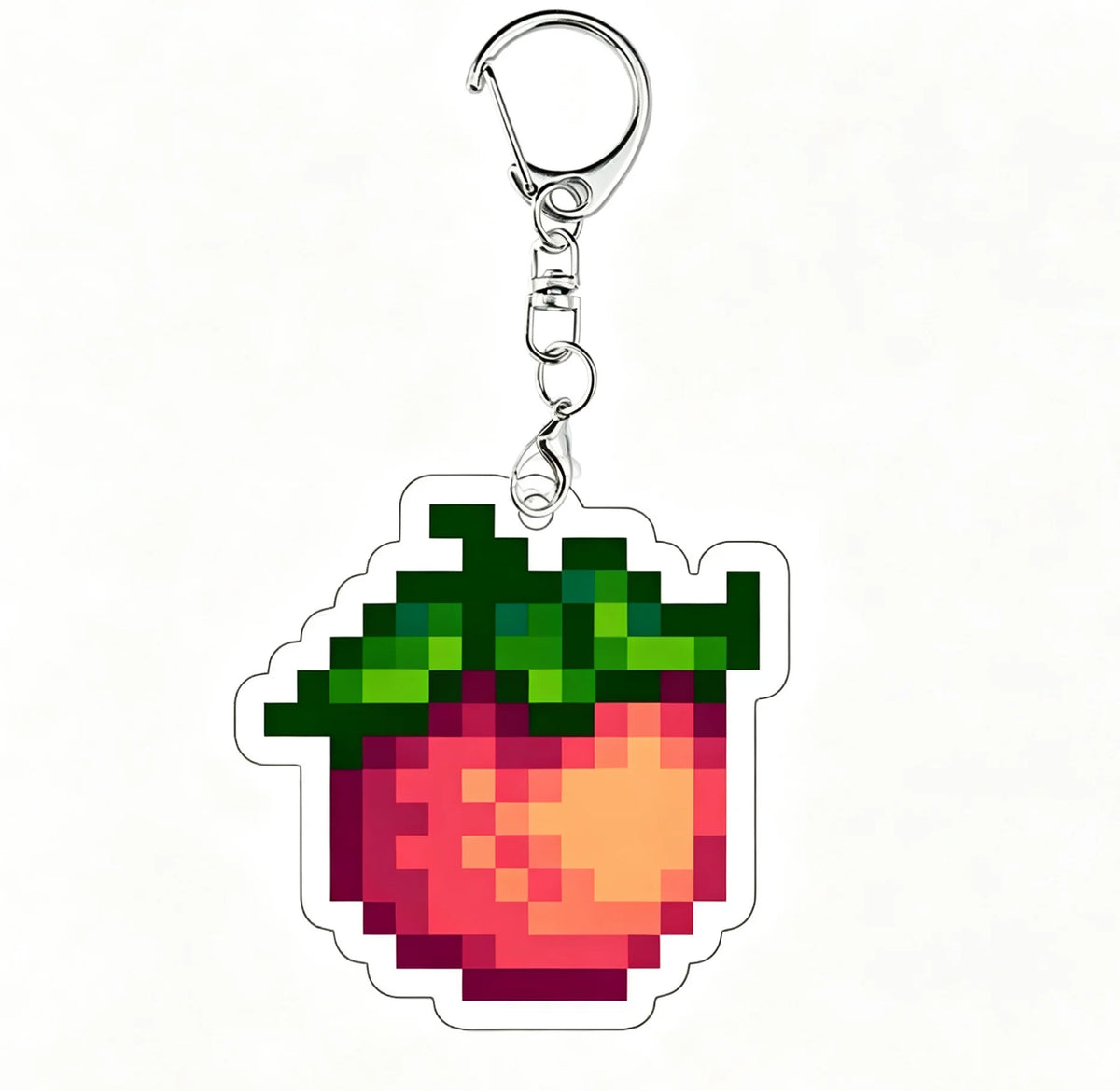 A clear acrylic keychain charm shaped like a strawberry with green leaves and red interior.