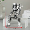 A silver mechanical piston skull sculpture standing on a white base.