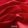 Close-up of rich red satin fabric draped and folded to show texture and sheen.