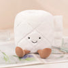 A white plush toy shaped like a toilet paper poop plunger, lying on an open book.