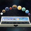 A display of nine natural crystal gemstone spheres representing the nine planets arranged in a line against a dark starry bac
