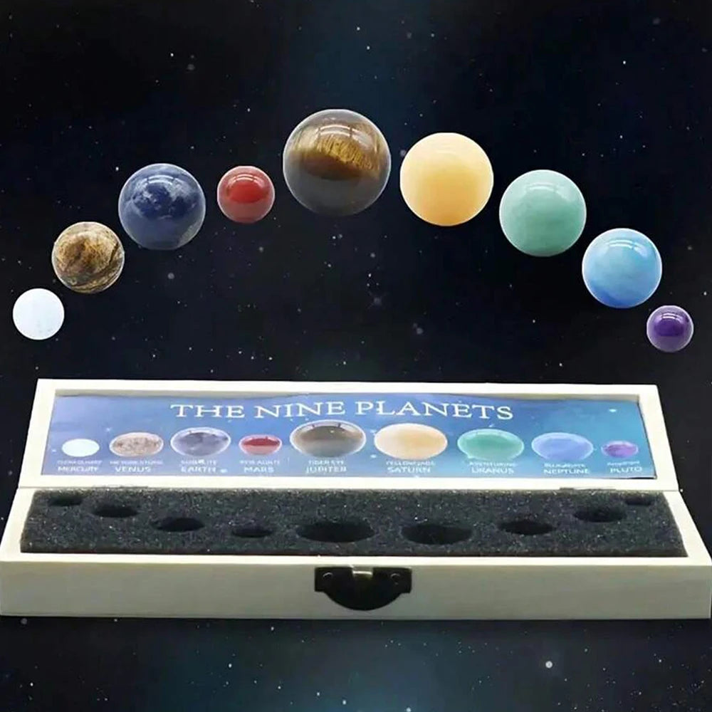 A display of nine natural crystal gemstone spheres representing the nine planets arranged in a line against a dark starry bac