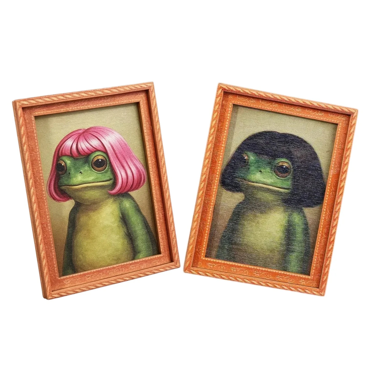 A pair of wooden photo frames featuring watercolor paintings of frogs, one pink and one green.