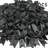 A pile of 50 black satin ribbon bows for gift wrapping and decor.