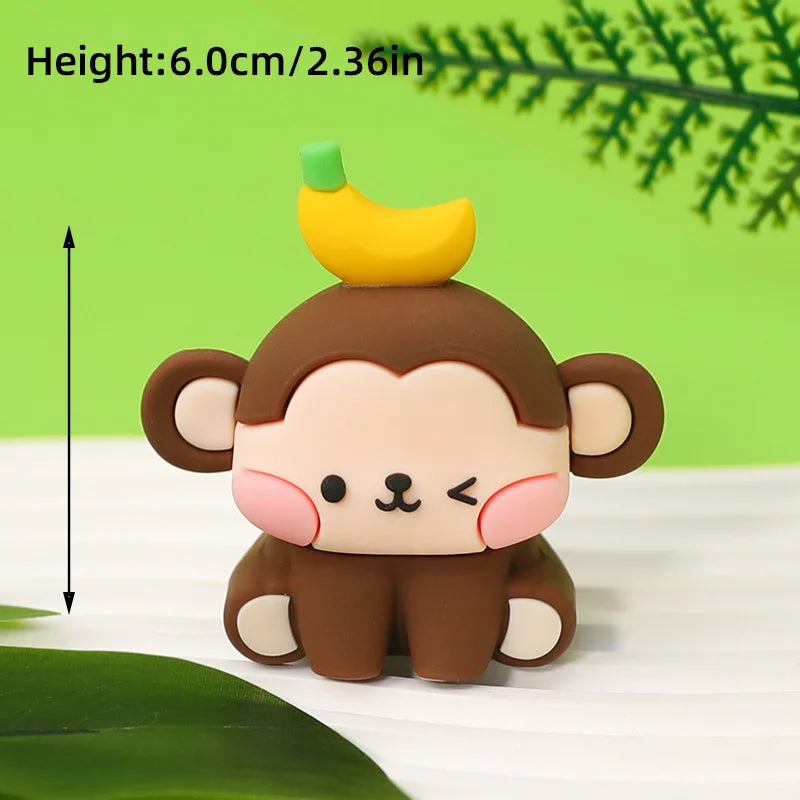 A cute brown monkey figure with pink cheeks and a yellow banana topper on a white surface.