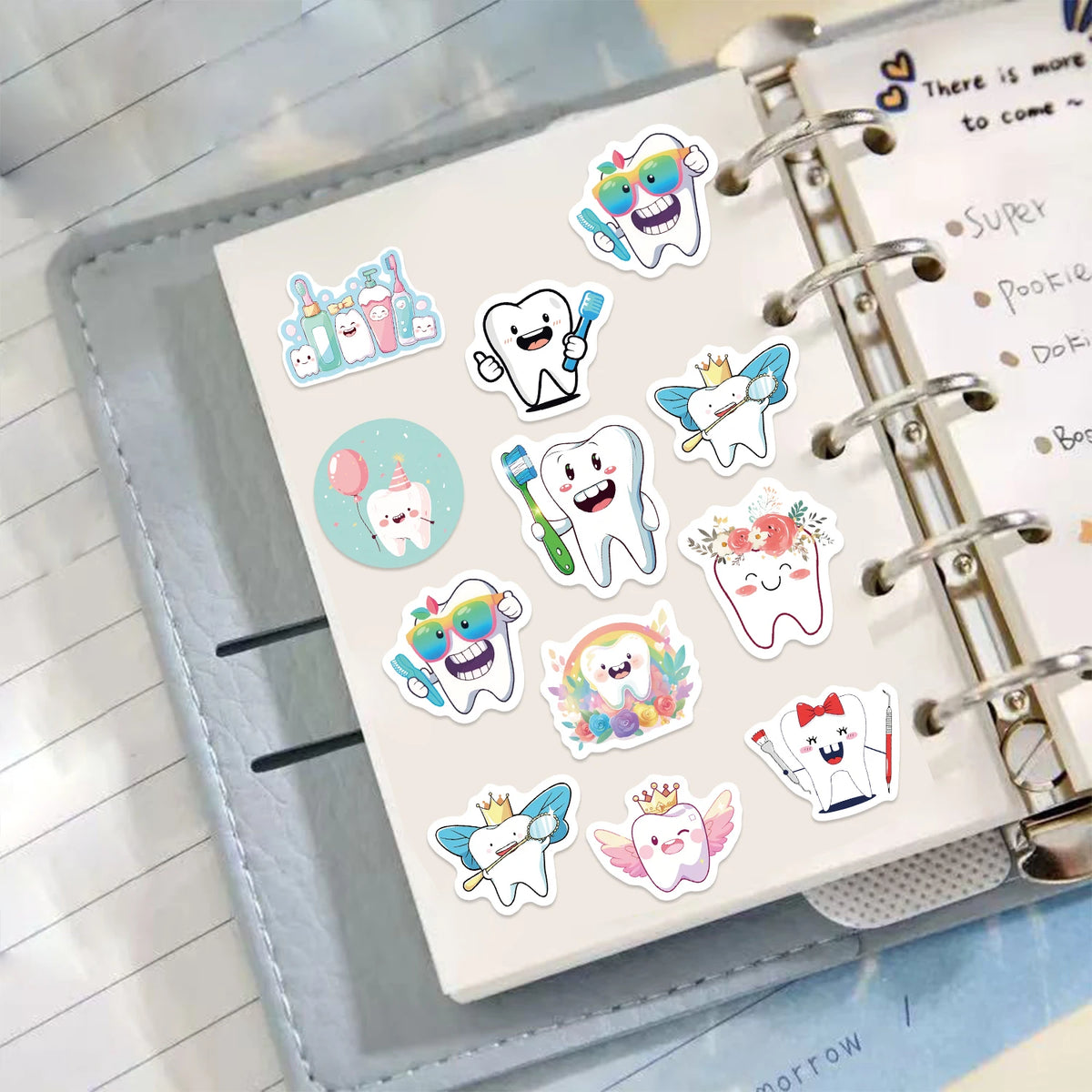 A collection of cartoon tooth fairy stickers on a spiral notebook page.