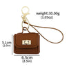 A brown mini leather openable bag keychain with a gold-tone clasp and leather strap.