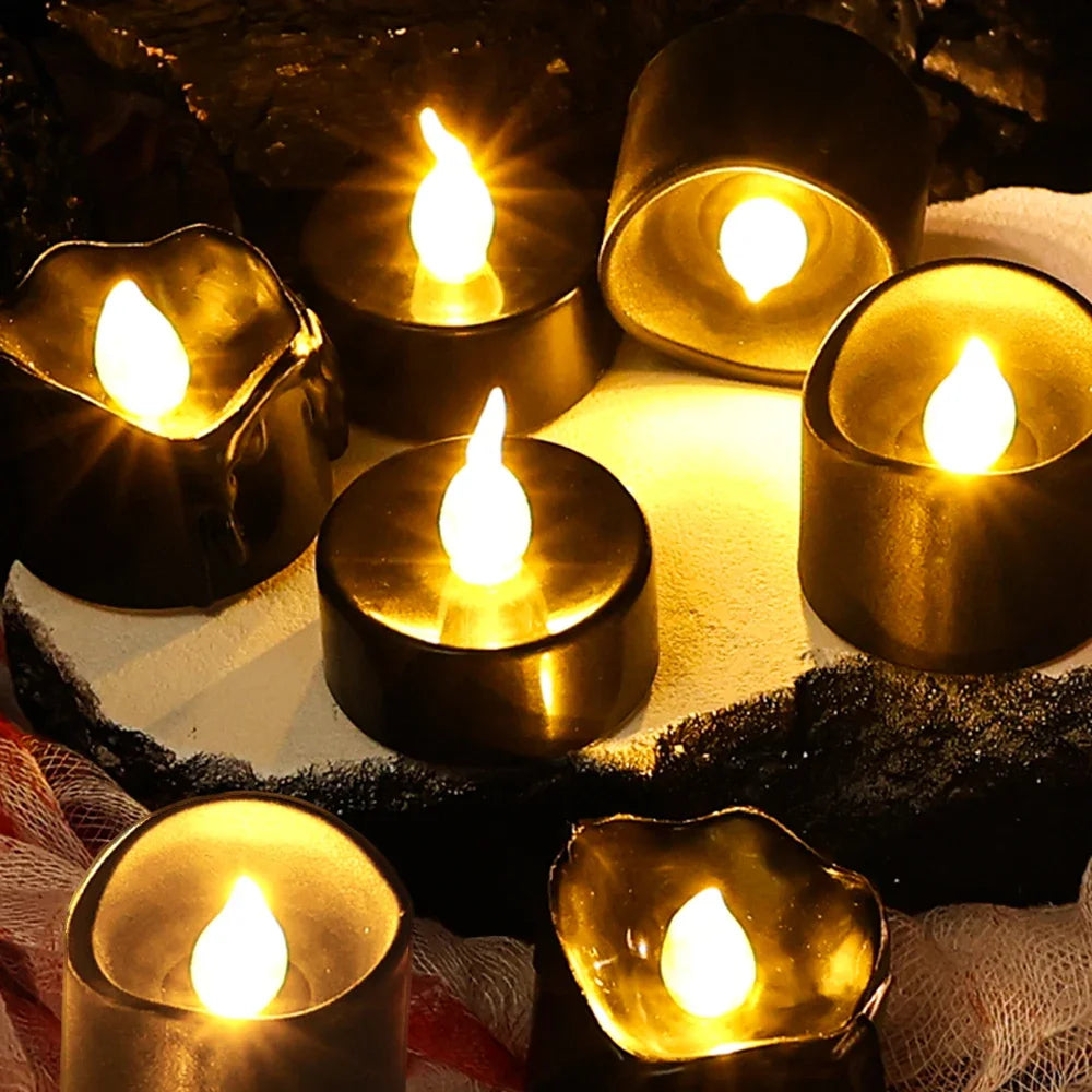 A collection of glowing black LED candles casting a warm white light on a dark surface.