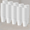 A stack of white reusable disposable paper cups in various heights and quantities.