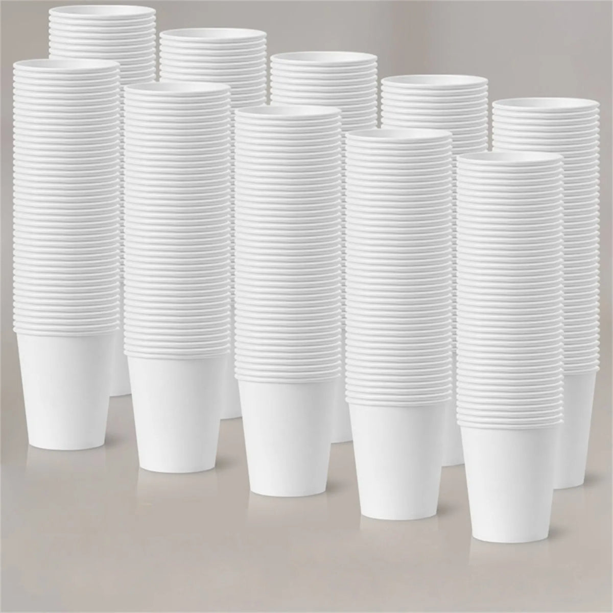 A stack of white reusable disposable paper cups in various heights and quantities.