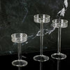 Three clear crystal glass candle holders displayed against a dark marbled background.