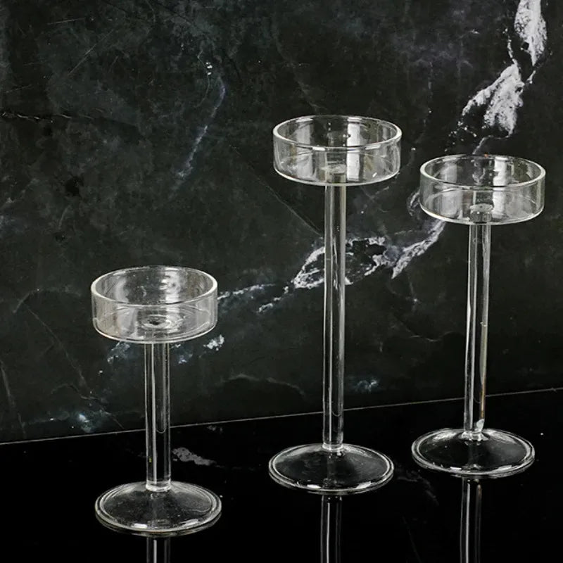 Three clear crystal glass candle holders displayed against a dark marbled background.