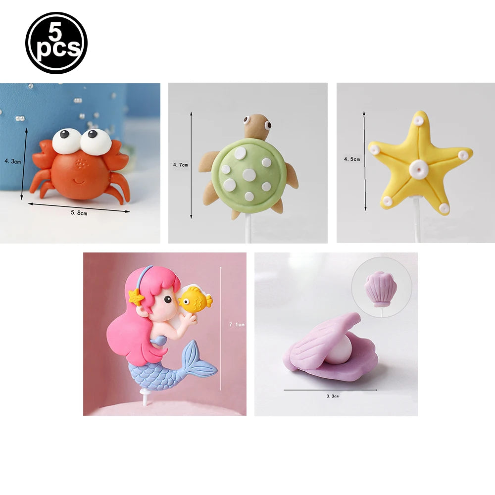 A set of five ocean animal cake toppers including a crab, turtle, octopus, whale, starfish, and shell decor.