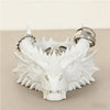 Tête de dragon en résine blanche pour bureau, avec dents acérées et un anneau argenté.